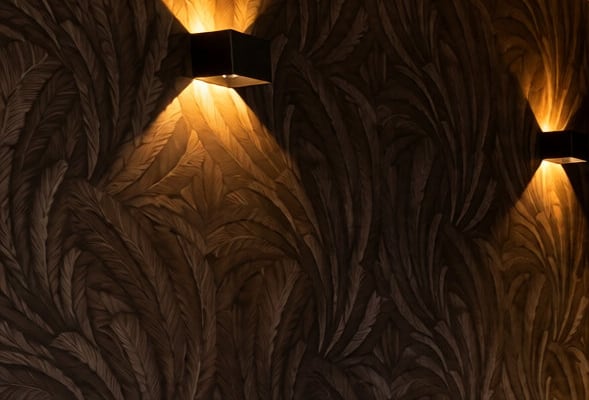 Behang met veren en warm wandlicht in de salon